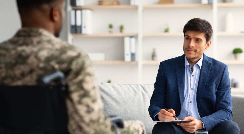 A veteran speaks with a service member, symbolizing guidance and support in navigating the VA claims process. The image highlights the role of Vet Claim Solutions, which helps veterans understand their rights, gather medical evidence, and strengthen their claims for conditions like Fournier’s gangrene. Expert assistance can make a critical difference in securing the benefits veterans deserve.