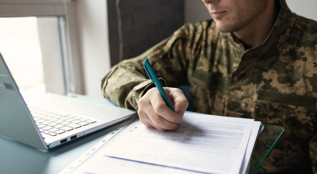 A veteran sits at a desk, filing a VA disability claim with documents and medical records in hand. Seeking compensation for Fournier’s gangrene, he navigates the process, highlighting the importance of medical evidence and persistence in securing VA benefits.