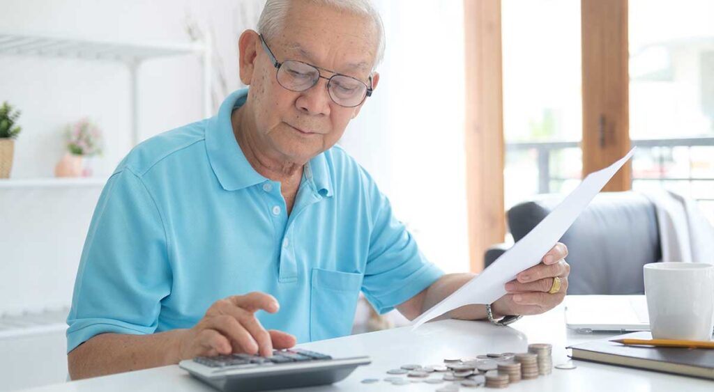 A man calculating expenses reflects the importance of staying informed. The 2025 Cost of Living Adjustment affects how much veterans receive in VA disability payments.